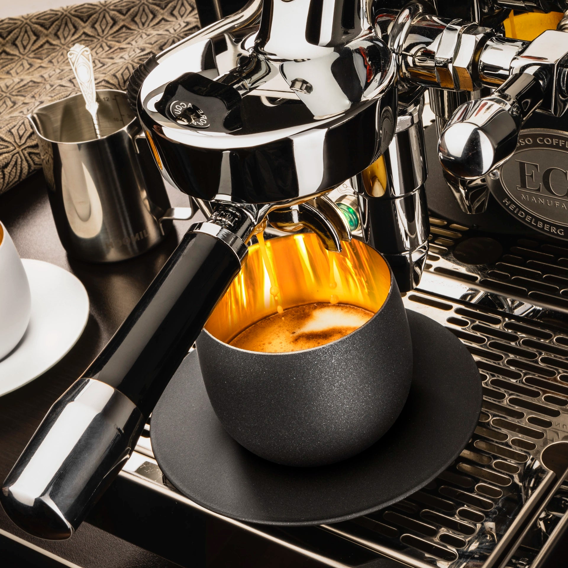 1001174-Eisch Cappuccinoglas mit Untersetzer - Cosmo gold in Geschenkröhre 109/3 unter Kaffevollautomat