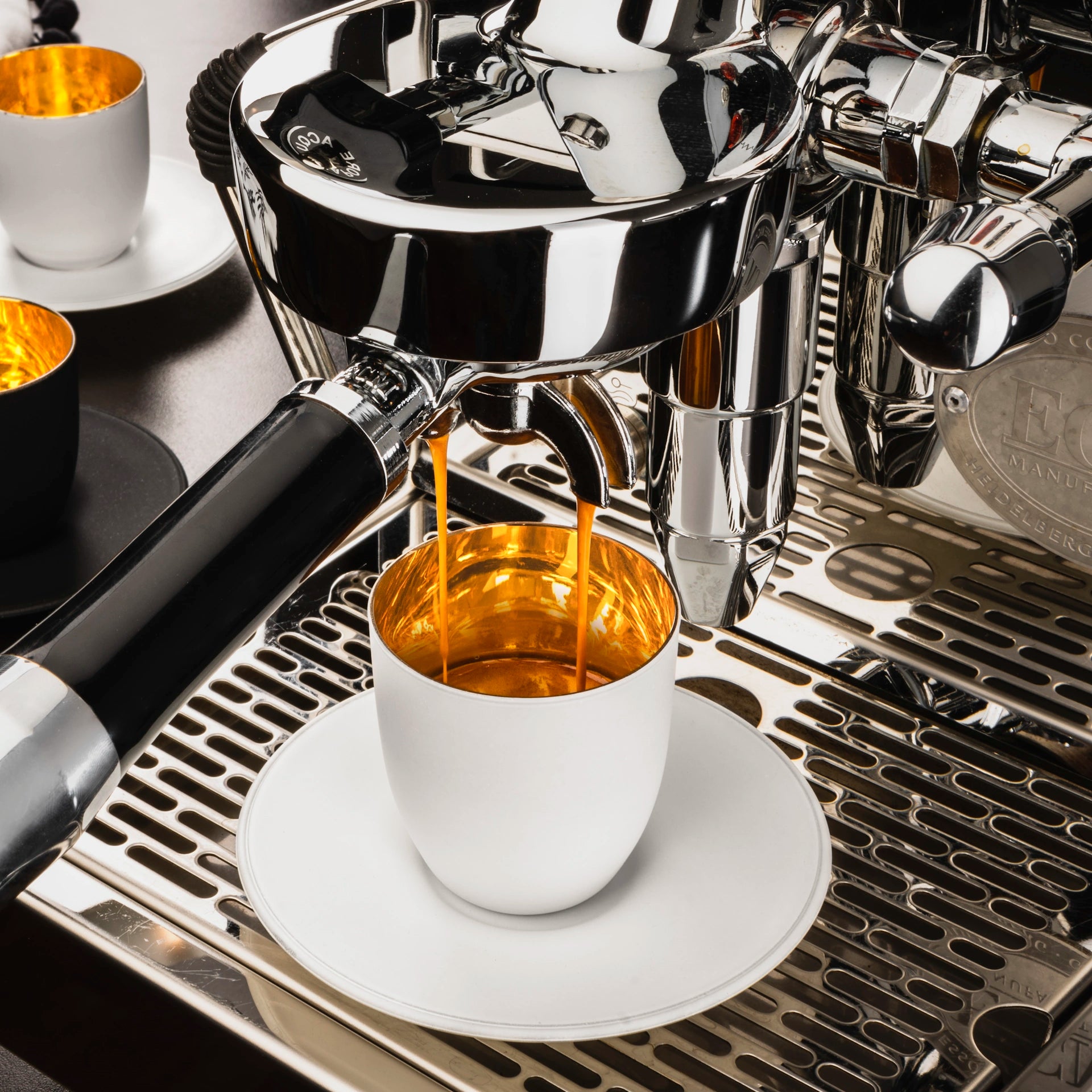 Eisch Espressoglas + Untersetzer - Cosmo gold/weiß in Geschenkröhre 109/6 am Espressoautomat